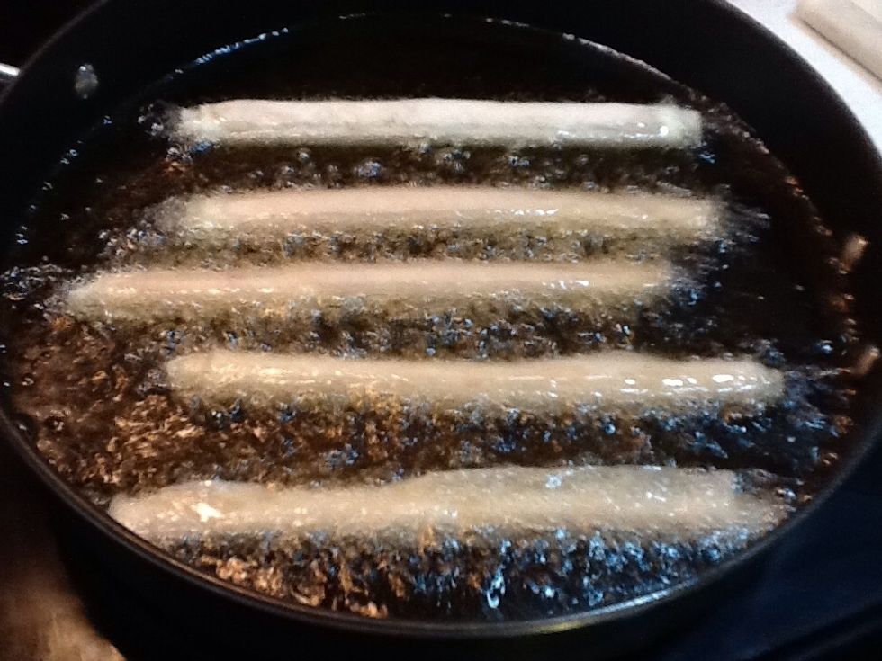 In a large pan, fry the Lumpia Shanghai in batches. Be careful of splattering oil, use tongs to brown all sides.