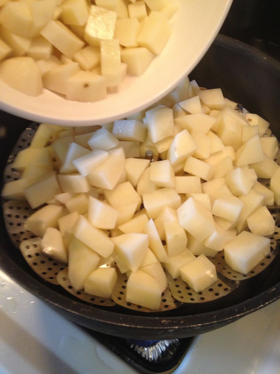 In a large pot with about an inch of water place a steamer basket. Bring the water to a boil and place the potatoes in it. Cover the pot and cook until potatoes are tender.