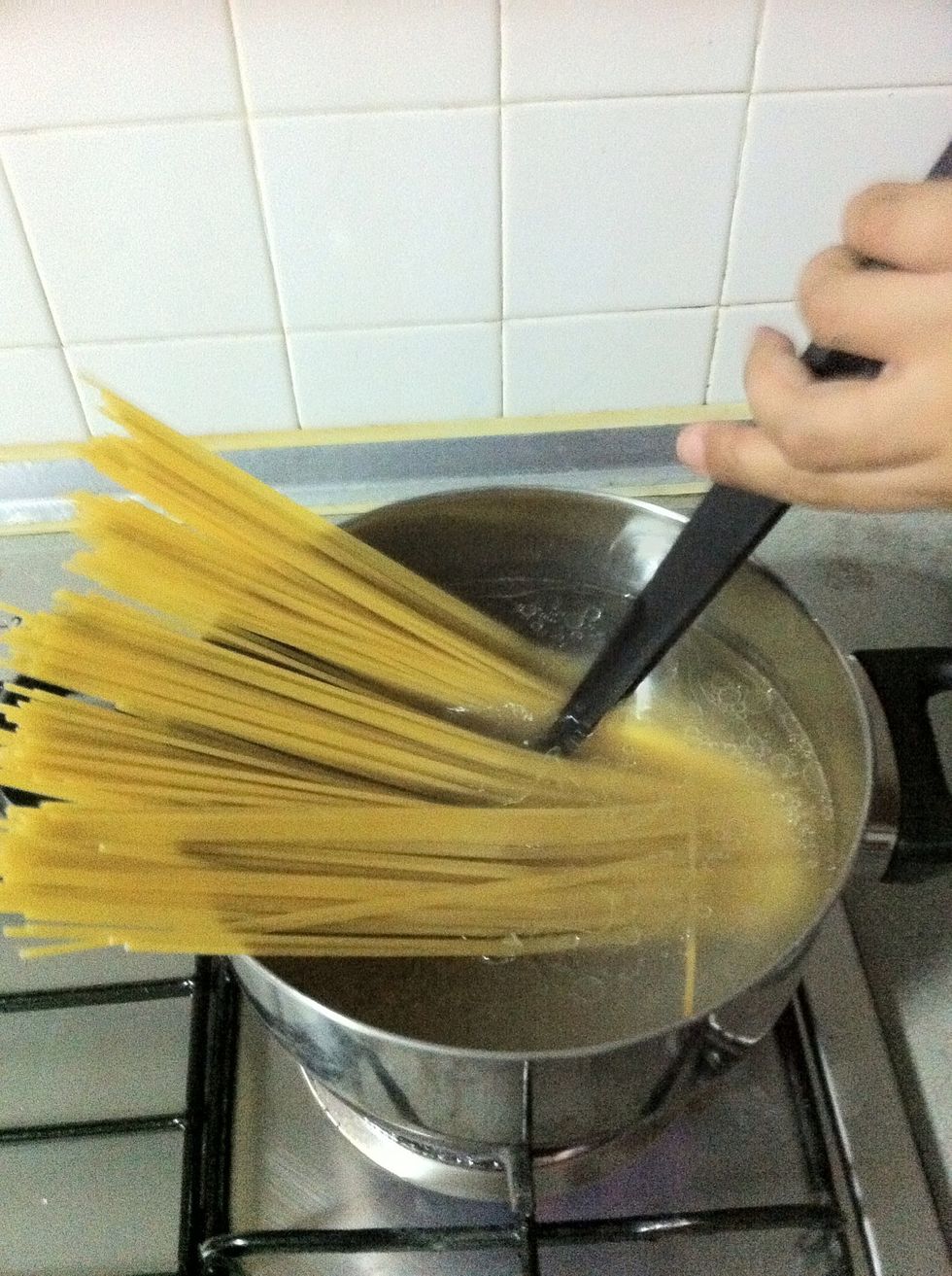 In a large saucepan, bring a liter of salted water with oil to a boil then add the spaghetti. (Traditionally they just use spaghetti for aglio olio in Italy)