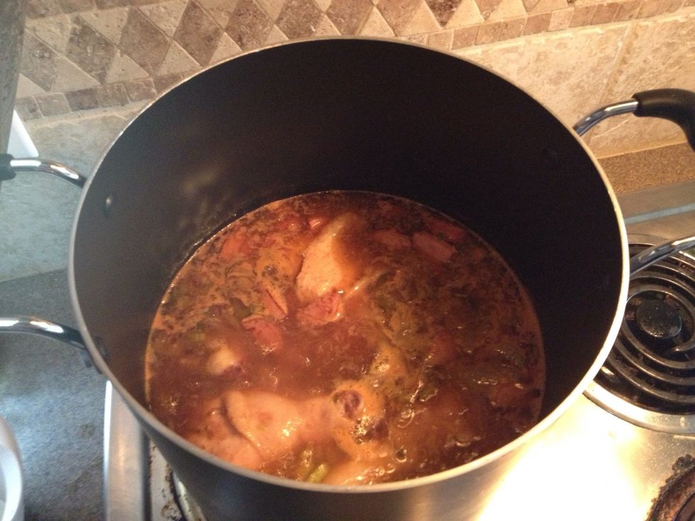 In a large stockpot, place chicken, sausage, saut\u00e9ed onions, celery, all your spices, garlic, water, chicken base, and chicken stock. Bring to a boil, then boil for about 15 minutes.