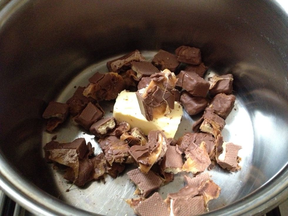 In a medium saucepan melt the mars bars and butter, mixing constantly with a wooden spoon and crushing the bars with the back of the spoon. Turn off the heat and mix in the cornflakes gently.