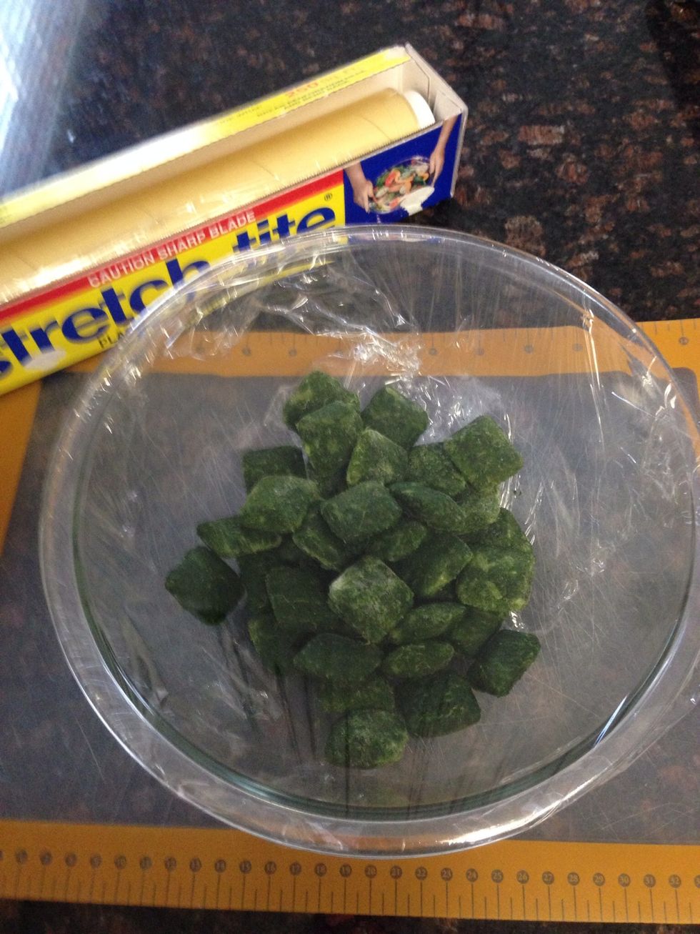 In a microwave safe bowl, place the spinach and cover with cling wrap.