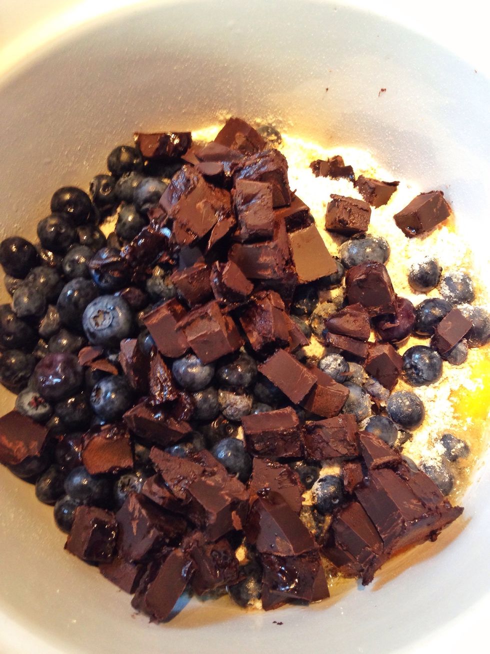 In a mixing bowl, stir in sugar, flour, baking powder, berries, eggs and cubed chocolate.