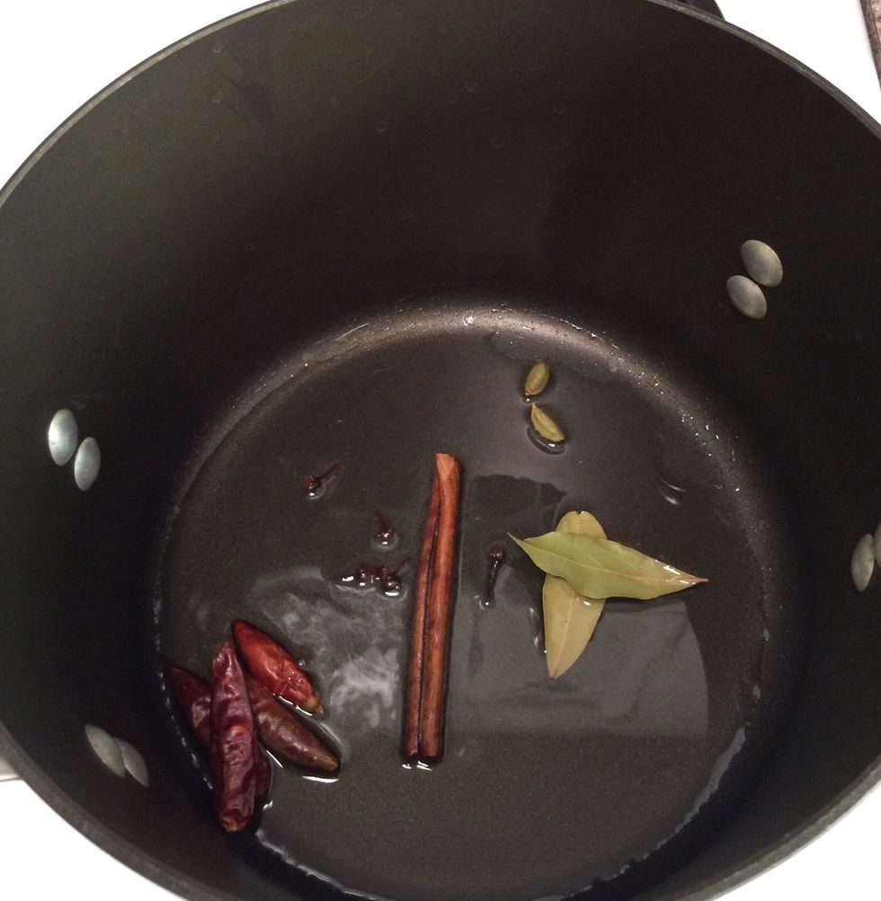 In a non-stick stock pot over medium heat; add oil. In about 1 minute add cloves, cardamoms, japanese chili pods, bay leaves and the cinnamon stick.