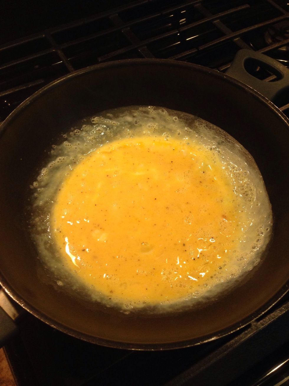 In a nonstick pan or greased/buttered stainless pan cook eggs on medium heat. Take off stove when they are nearly cooked through. (they will finish cooking in oven)