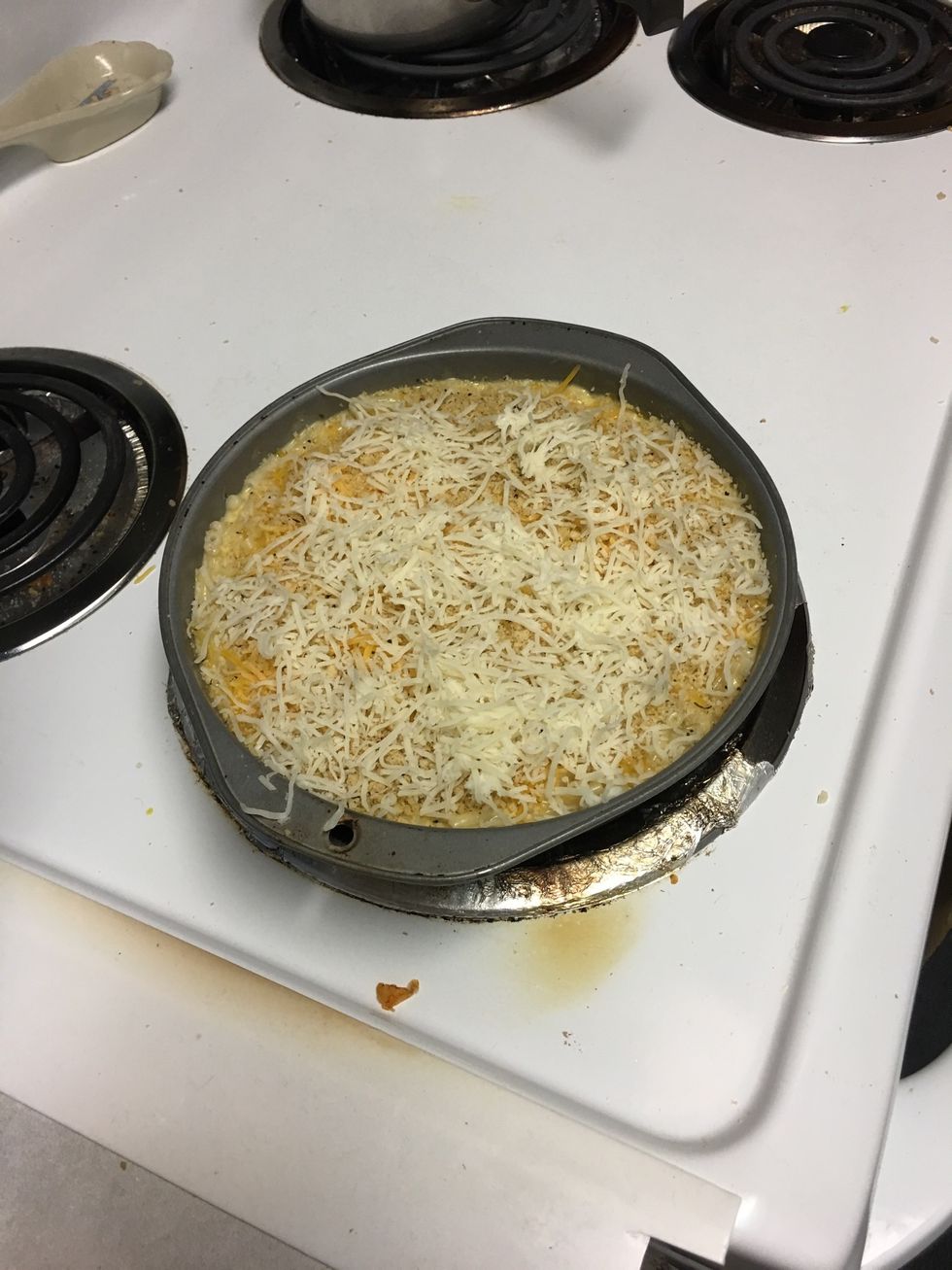 In a pan stir together mixture and noodles and then cover with shredded cheddar cheese, shredded mozzarella cheese, and breadcrumbs