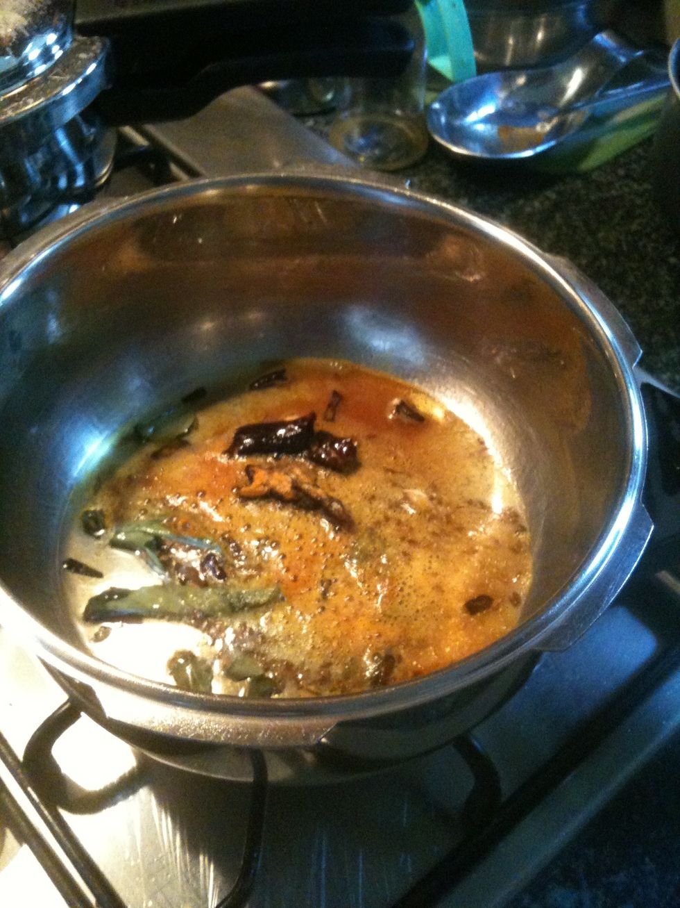 In a pressure cooker heat olive oil, add curry leaves, dried chili, cinnamon stick, cloves, cumin seeds,turmeric powder, asafetida.