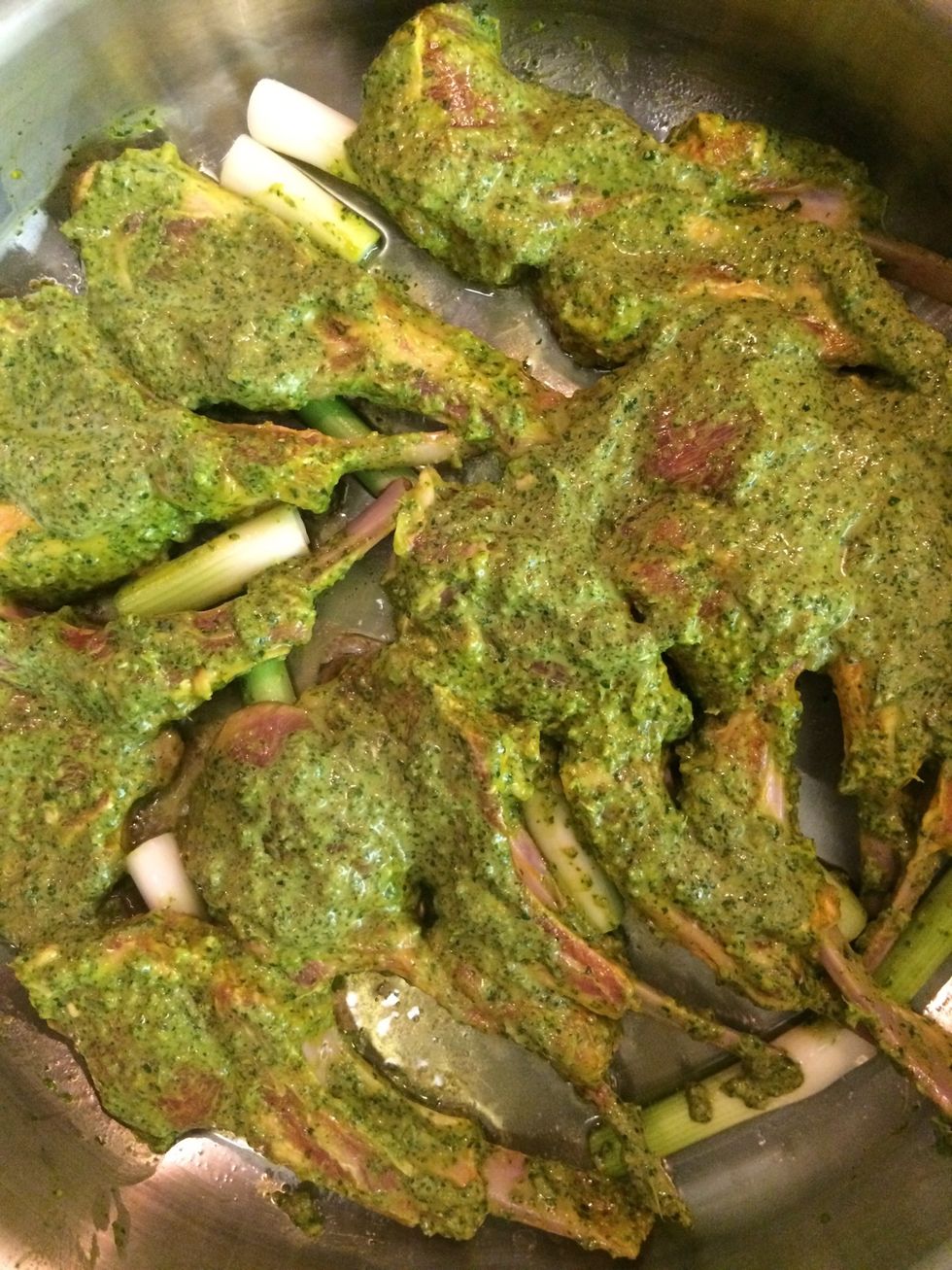 In a shallow pan over medium heat, add 1/4 cup garlic olive oil, green onions and the marinated lamb chops. Sear both sides for about 3-5 minutes.