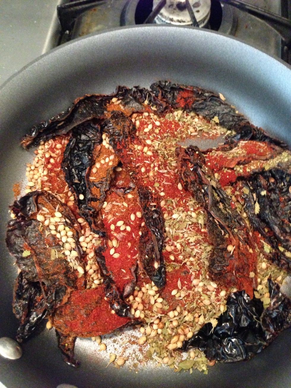 In a small dry skillet over low heat add the ancho peppers, oregano, paprika, coriander, cumin, and chili powder. Cook until they begin to smell, about 2 minutes.
