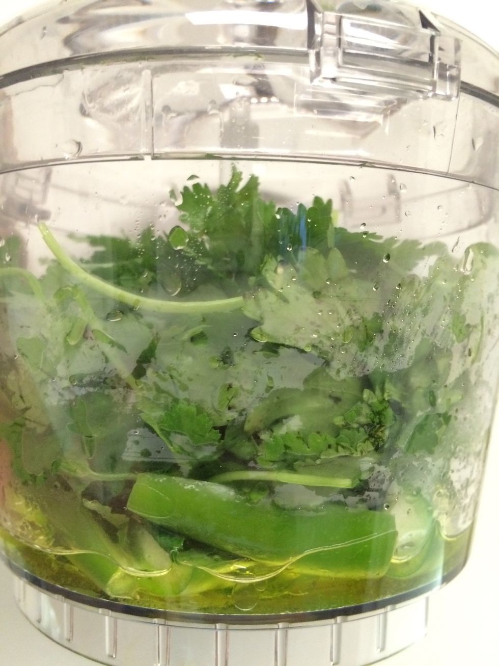 In a small food processor, pour 1/4 cup of garlic olive oil, cilantro, mint leaves and serrano chili peppers. Grind these to a paste.