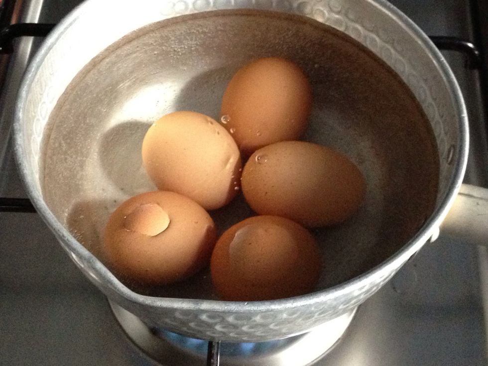 In a small saucepan add in some water (room temp) and 2 tsp of salt. Add in the 5 eggs. Bring the water to a full, rolling boil and cover te saucepan. Turn off the heat and covered for 12 mnts.