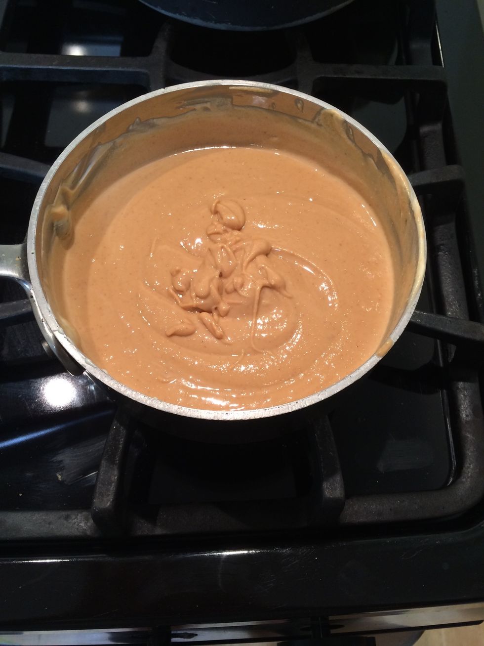 In a small saucepan, combine the white chocolate and peanut butter. Warm over medium heat until almost melted, continuously stirring. Set aside to cool slightly.