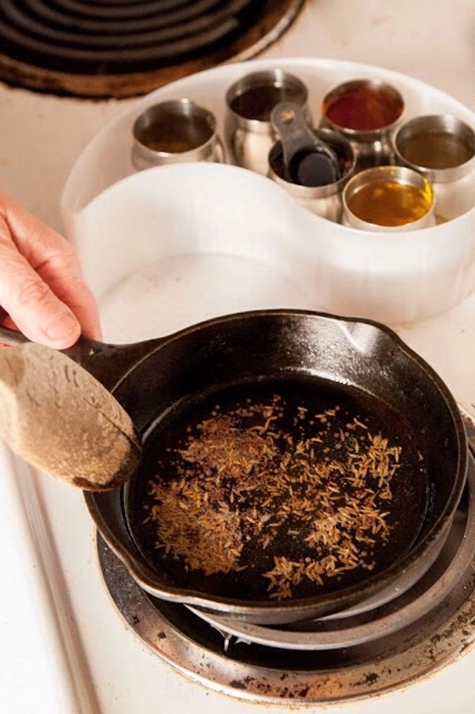 In a small skillet or pan heat 3 tsp of vegetable oil. When the oil is hot, add in the mustard seeds and cumin seeds.