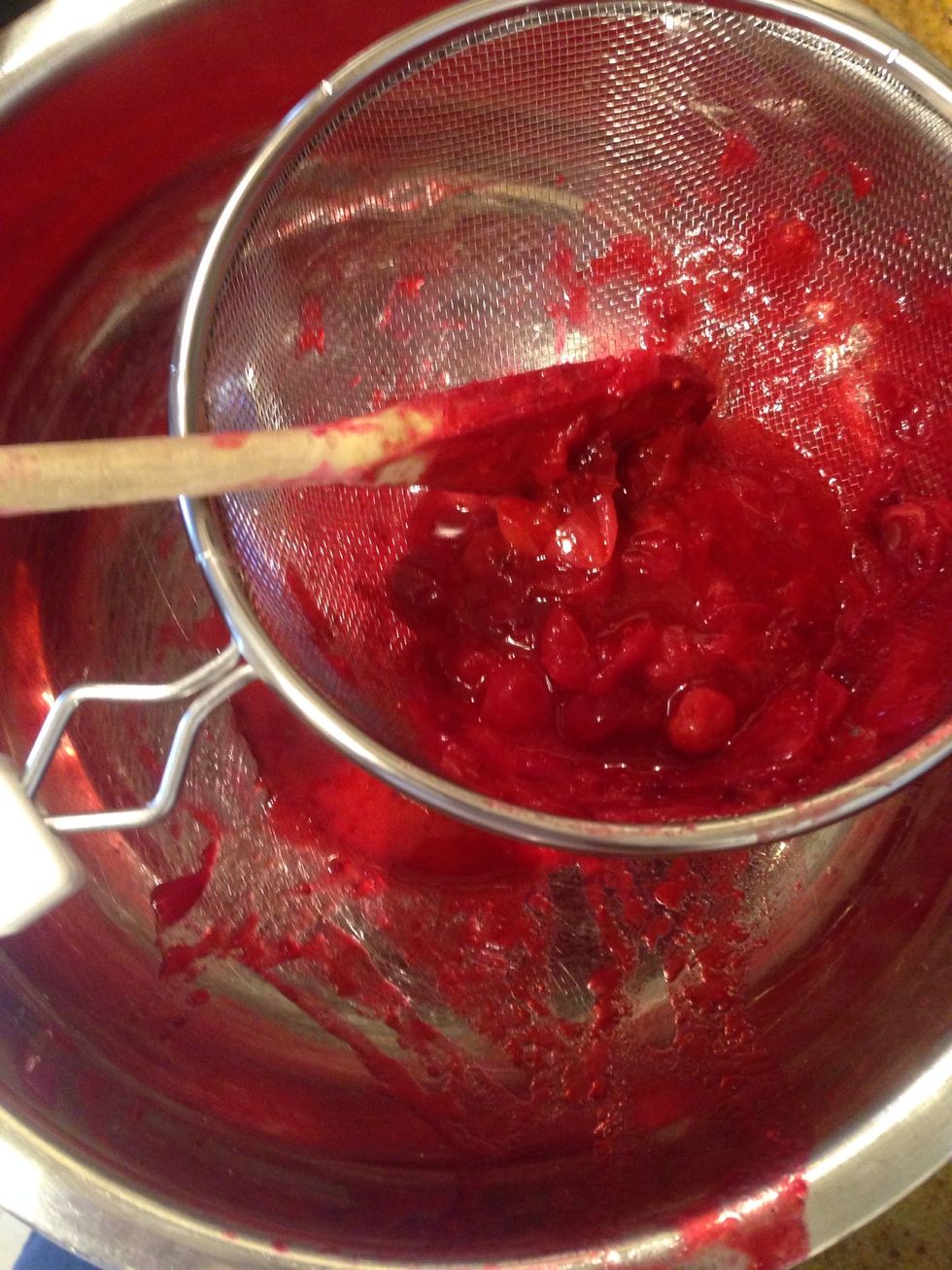 In a strainer, over a bowl, place a ladle full of cranberries w/ juice & using a hard spoon squish the berries against the strainer. U want to keep squishing until the only thing left is skins.