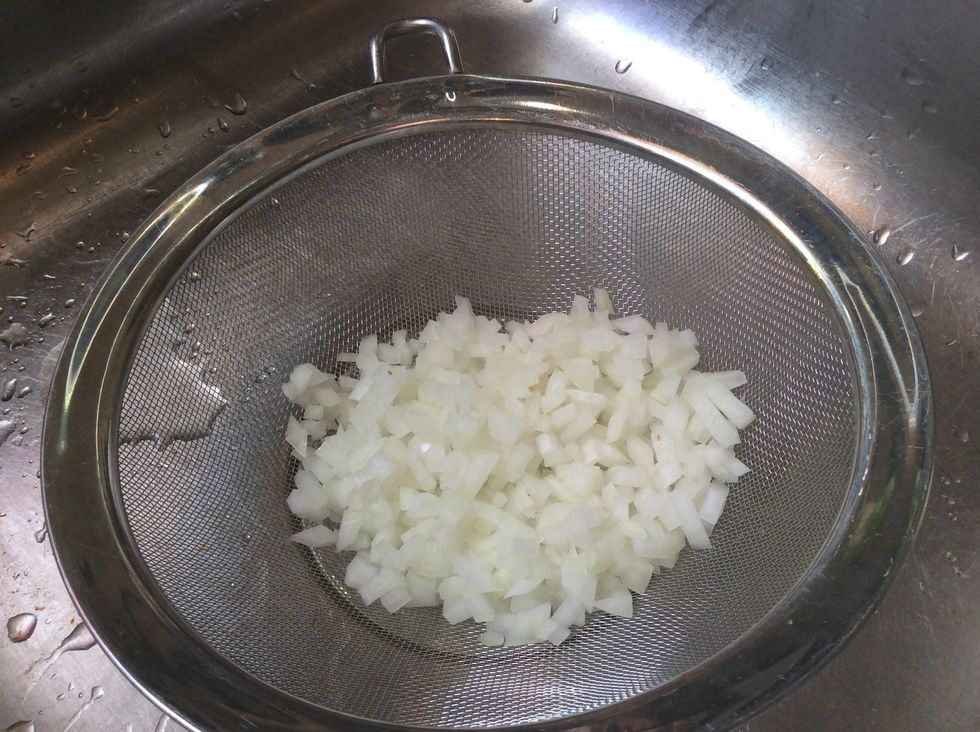 In a strainer. Rinse with cold water, and let drain. This will take the "onion-y bite" out. (Cool tip right?)