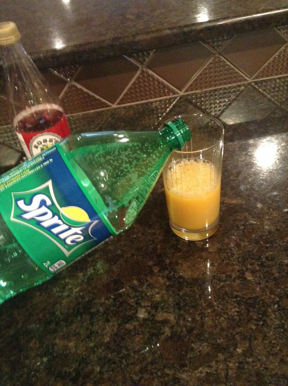 In a tall glass, combine orange juice and Sprite.