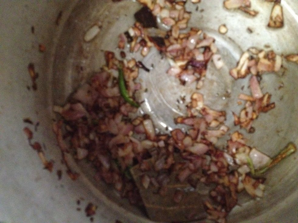 In a thick bottom pan hear oil and add cumin, cloves, peppercorns, bay leaf , onion and green chillies and fry till it turn brown.