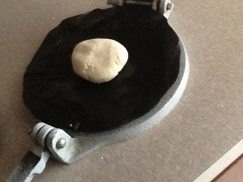 In a tortilla press place a dough ball between 2 sheets plastic like this