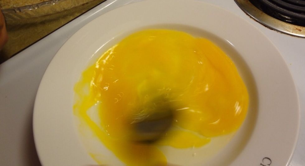 In a wide shallow bowl, beat two eggs.