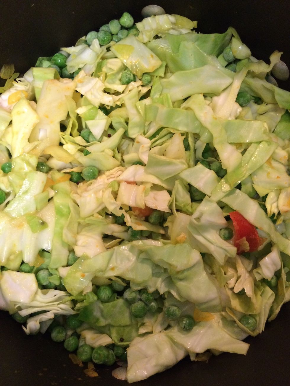In about 2-3 mins. add cabbage and peas. Keep mixing constantly.