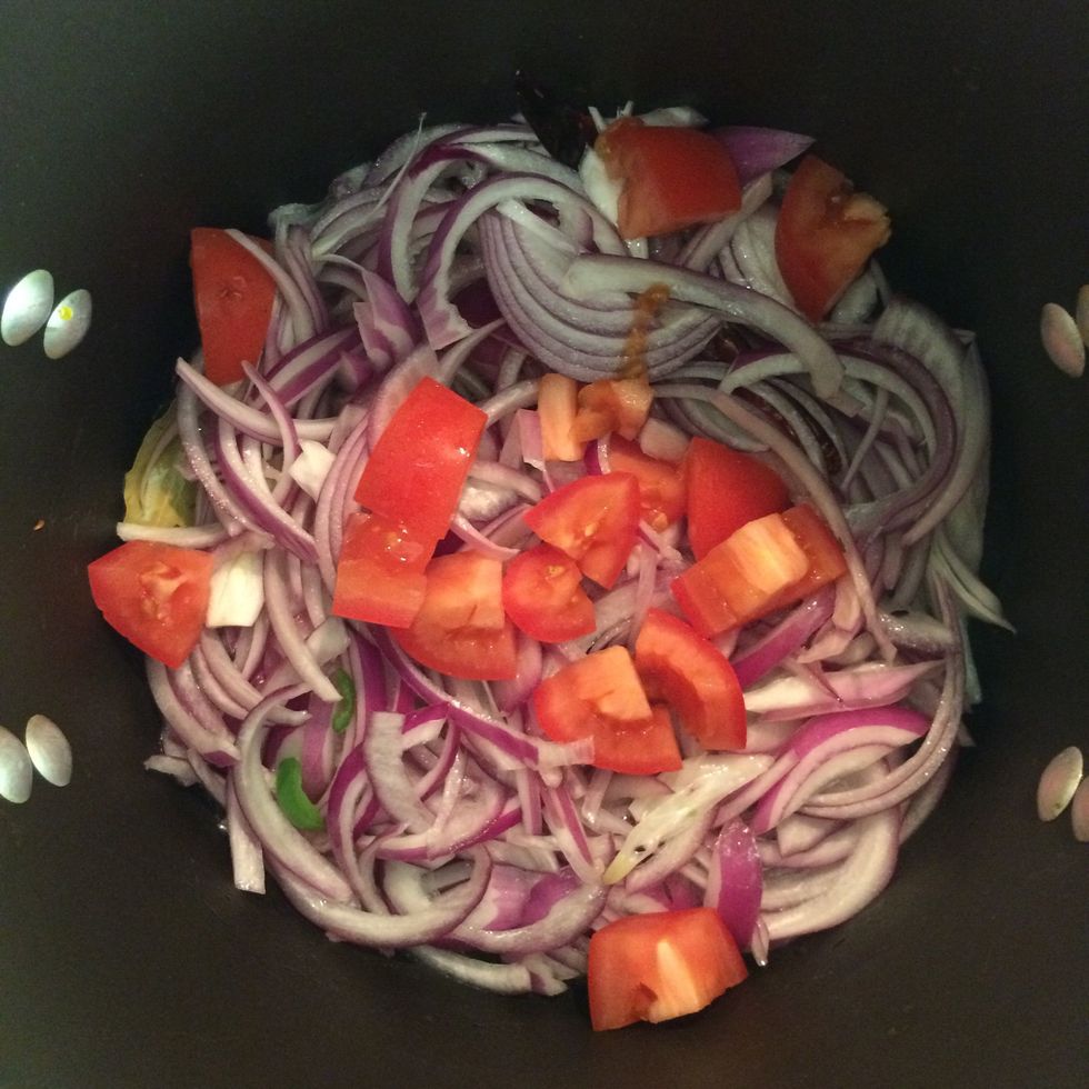 In about 2 mins. add the chopped onions and tomatoes. Mix well.