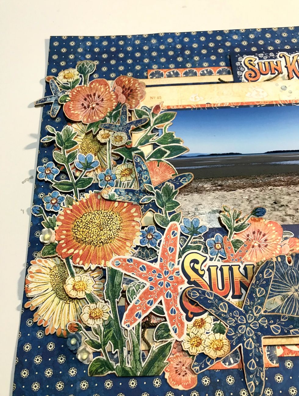 In amongst the flower bunch, adhere 3 starfish, 2 daisies, 1 pink sand dollar, 2 white flowers and 1 blue flower.