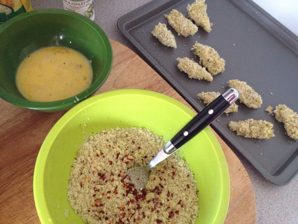 In another bowl whisk 2 eggs. Dunk the artichoke in egg then coat with bread crumbs. (best to use for this step). Then lay flat on greased baking sheet. (I almost forgot the pepper flakes!)