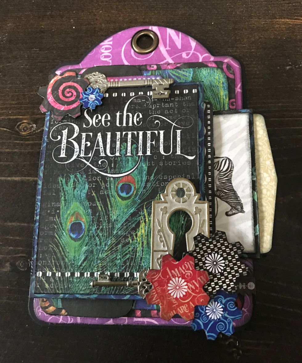 In bottom right corner of See the card, adhere a metal key hole and key. Use adhesive and foam squares to adhere the remaining three flowers.