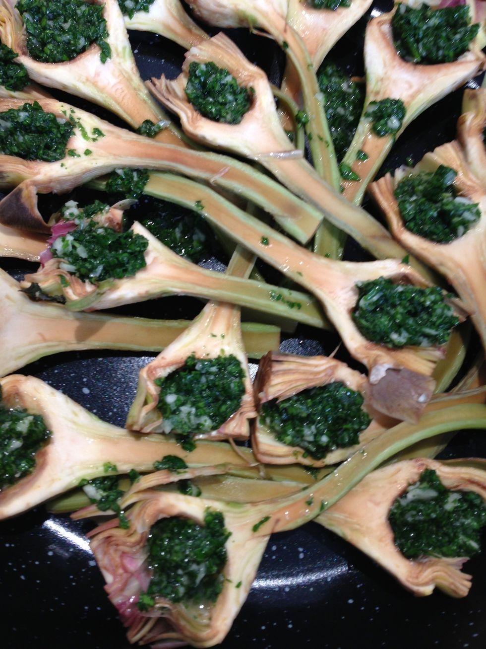 In each half artichoke, put a teaspoon of the mixture. If some remains just add them in the pot. Add 2TBsp water 1-2 TBsp olive oil. Cover. Bring to a boil. Cook on low for 1 hr or until tender