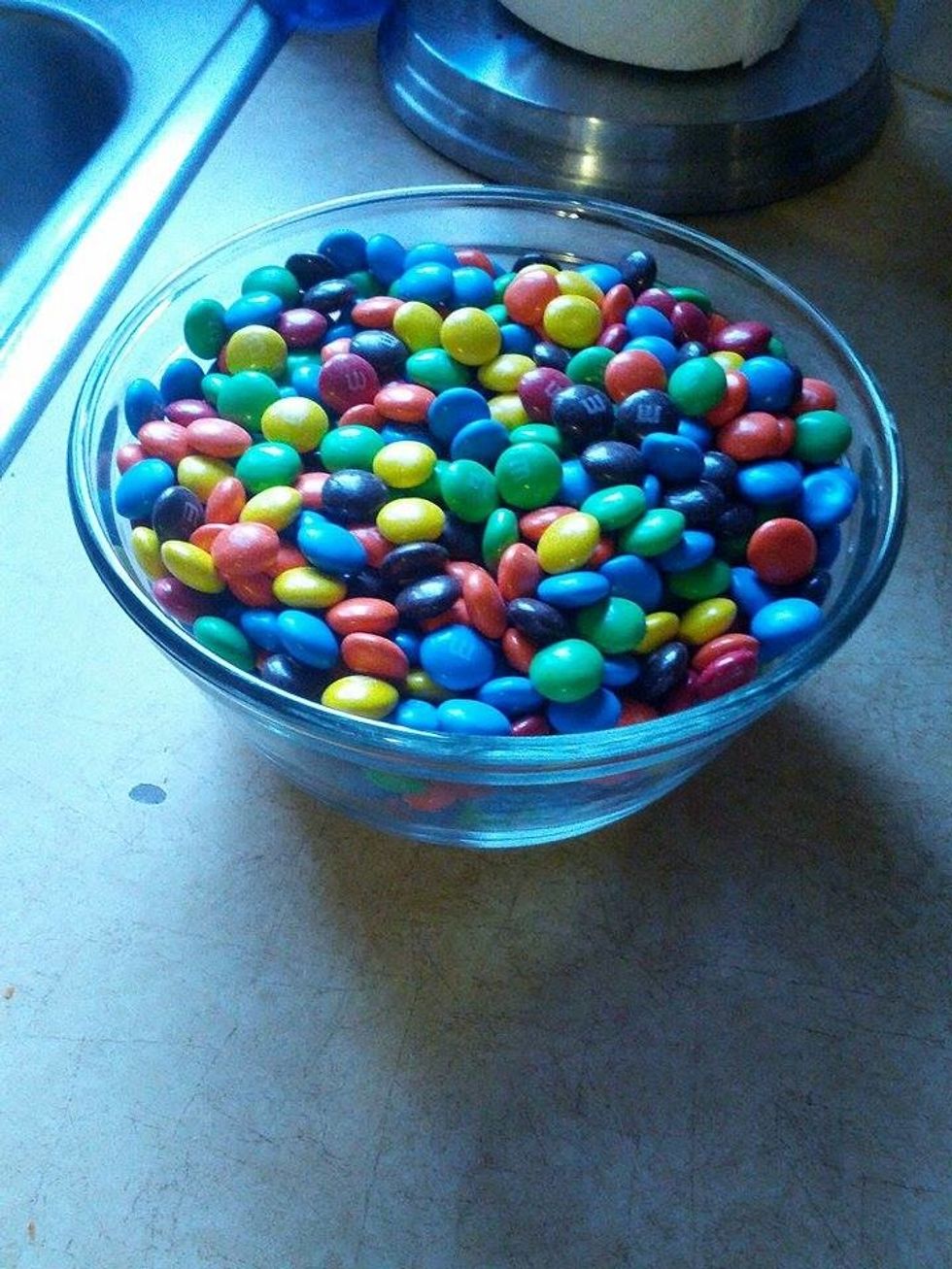 In one of the bowls put the two cups of candy-coated milk chocolate candies in a separate bowl for later.