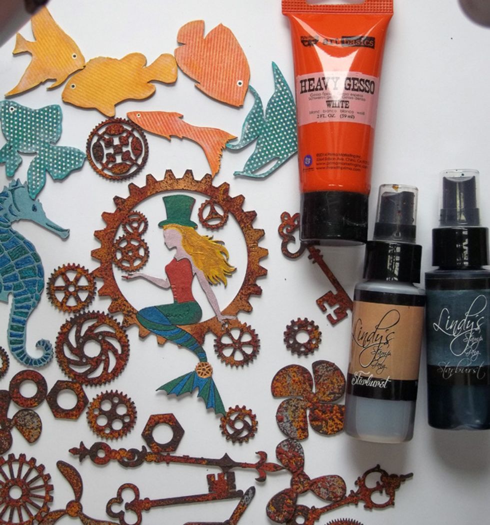 In order for chipboard elements to blend with bottle decor, lightly sponge all chipboard with heavy white gesso & spray with Steampunk Sepia Mist. Splatter rusted areas with Tainted Love Teal Mist.