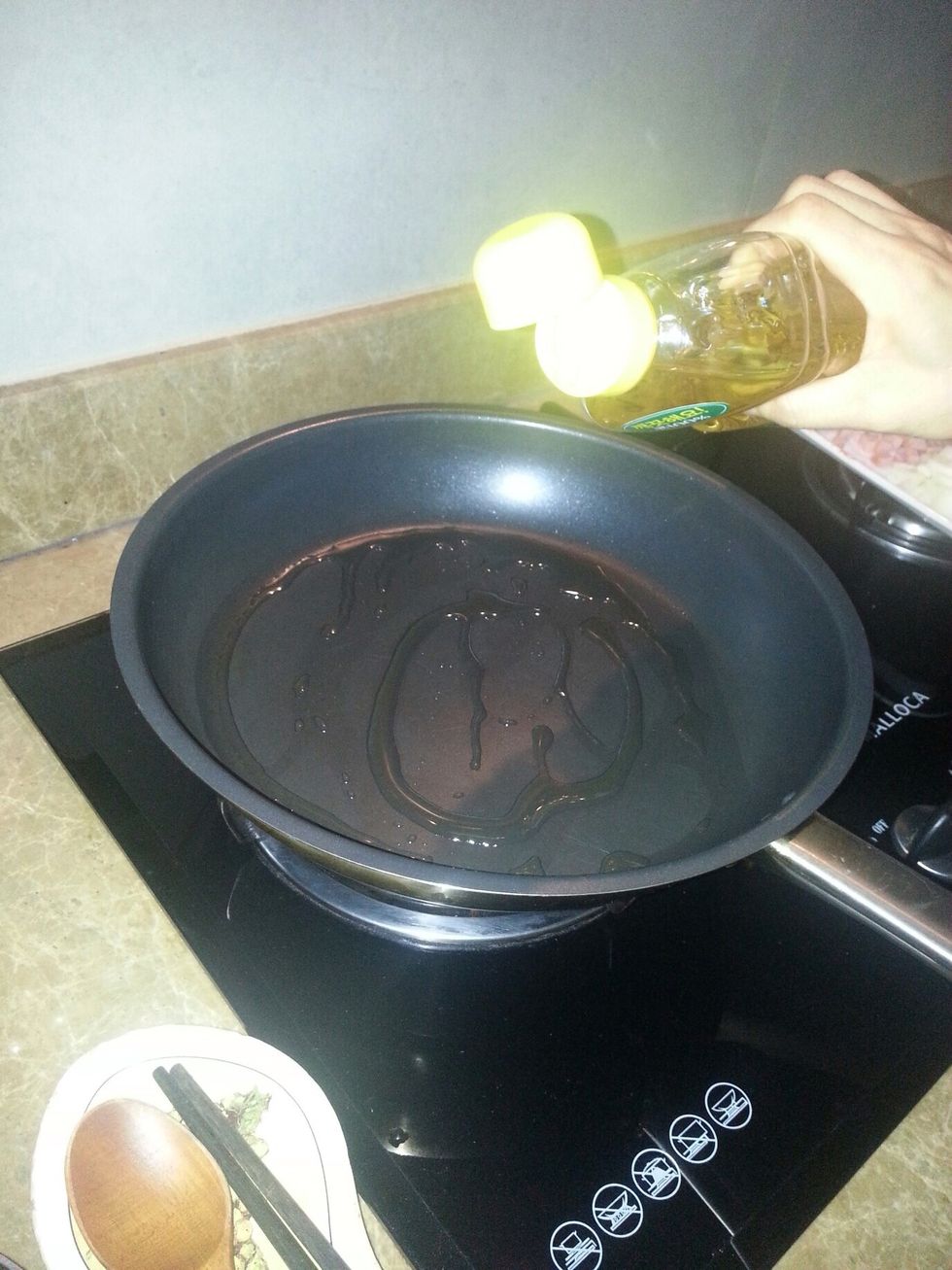 In the big frying pan, pour the cooking oil around the frying pan.
