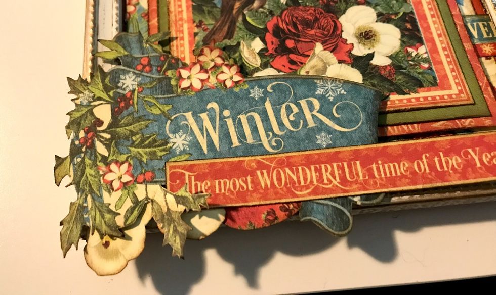 In the bottom left hand corner of the frame, adhere the winter banner, a white flower, an orange and the Most Wonderful banner.