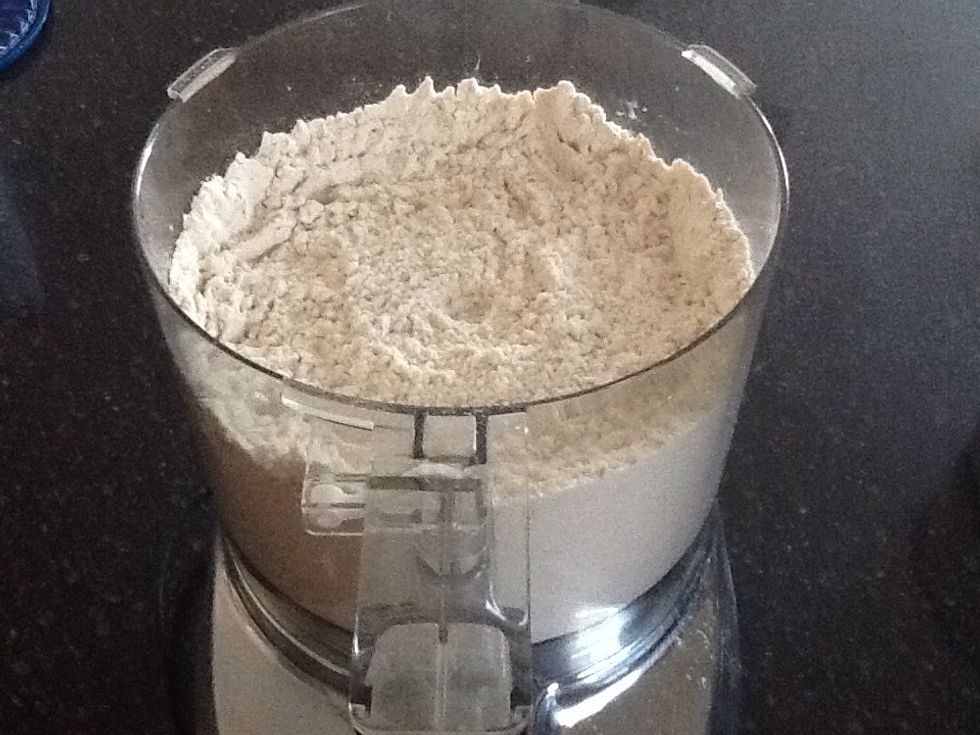In the bowl of a food processor, combine yeast, flour, salt, and 1 teaspoon sugar. Process until combined.
