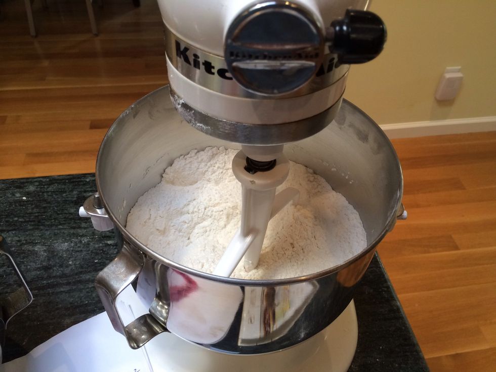 In the bowl of an electric mixer fitted with the paddle attachment, combine 6 cups of flour and 1 teaspoon salt.