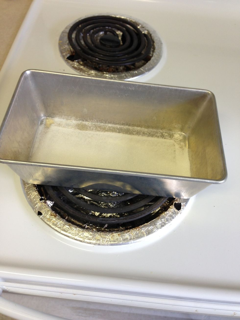 In the bread pan add 3 tbsp of sugar place over heat and let sugar melt it doesn't have to be black just make sure it melts . Hold pan with cloth to not burn ur hand ..