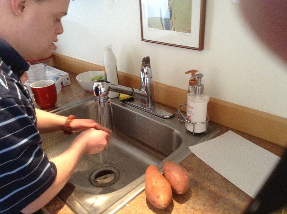 In the kitchen sink scrub the sweet potatoes