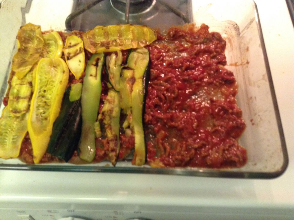 In the lasagna dish, put a thin layer of bolognaise, with a layer of veggies on top...