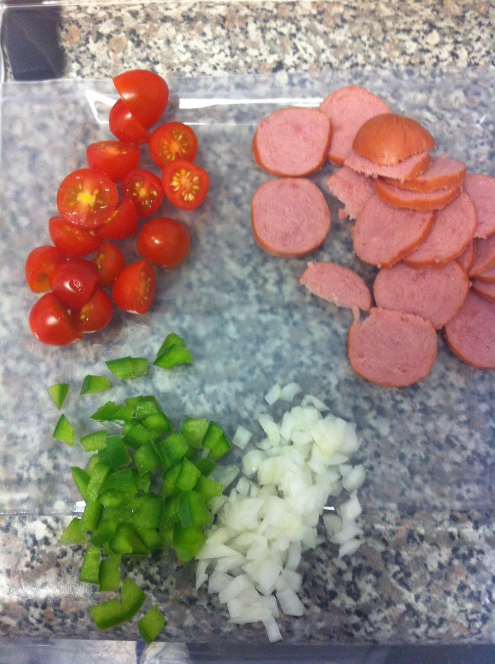 In the meantime, chop the rest of your ingredients. Add the oil to a pan, brown the sausage and garlic. Add onion, tomato and pepper. Cook 5 minutes or until softened.