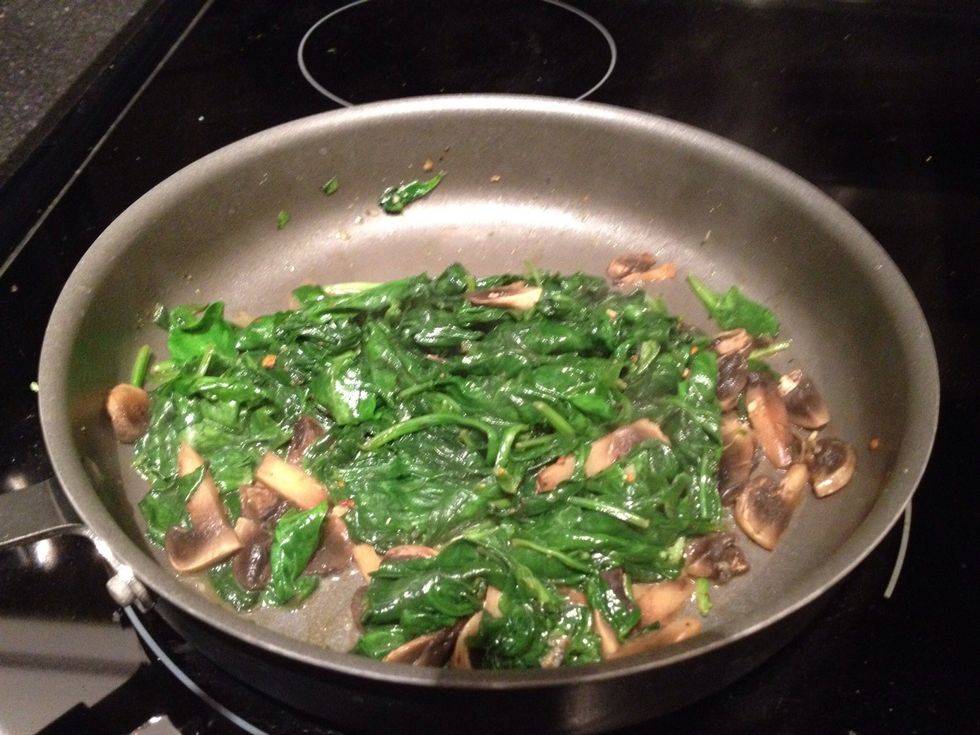 In the meantime, while the fish is cooking, grab your spinach and mushrooms. Saute the mushrooms for a bit on medium heat, then add the spinach with more salt, olive oil, and pepper. Wilt it down.