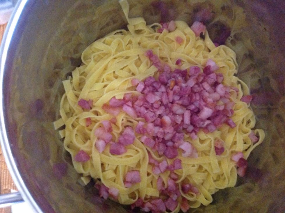 In the pot (still on the cooker) put the bacon with the fettuccine and the cream. Stir all the ingredients quickly