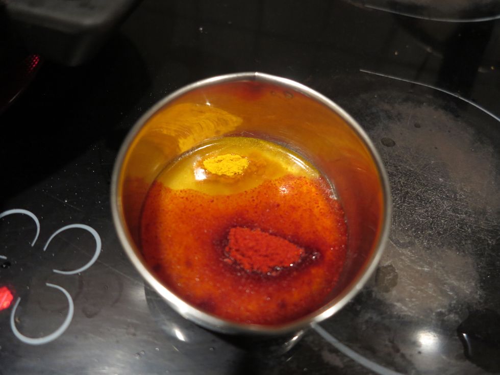 In the removed oil, add the turmeric and chili powders. The chili powder is mainly for colour and does not make it spicy. If your powder is spicy, then you can skip the green chilies.
