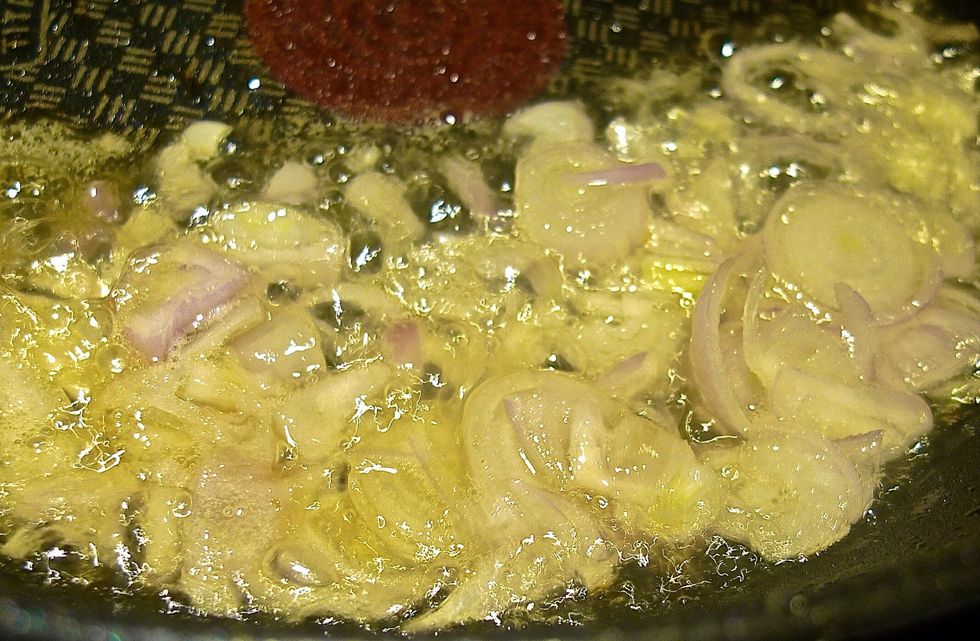 In the same wok, heat up oil and saut\u00e9 sliced shallots until fragrant and golden brown.