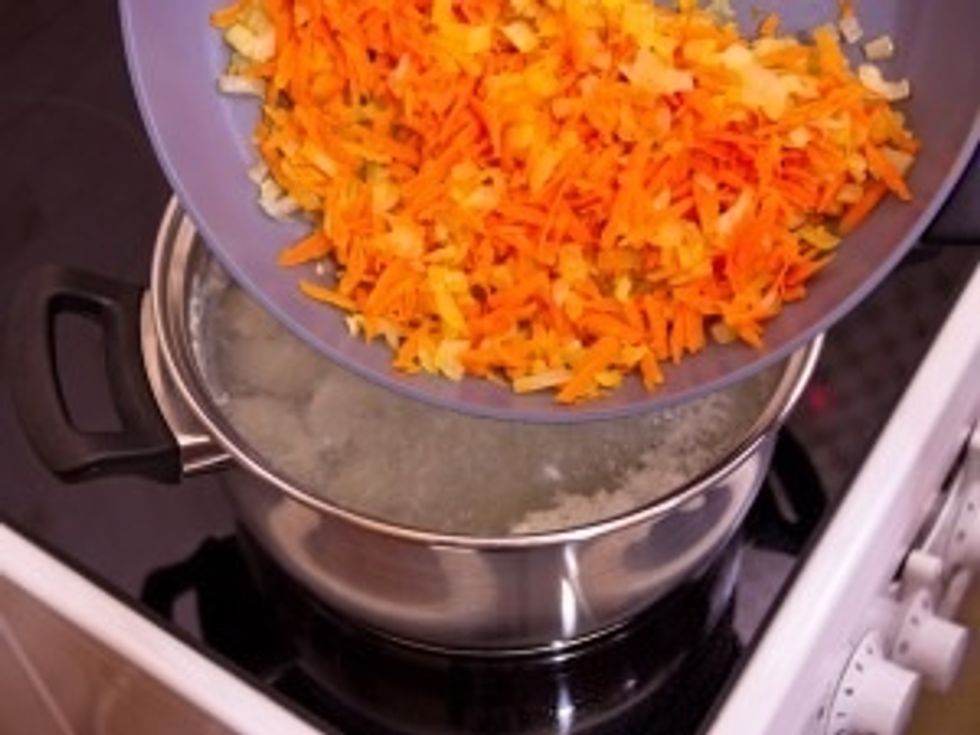 In the soup add the onions and carrots.
