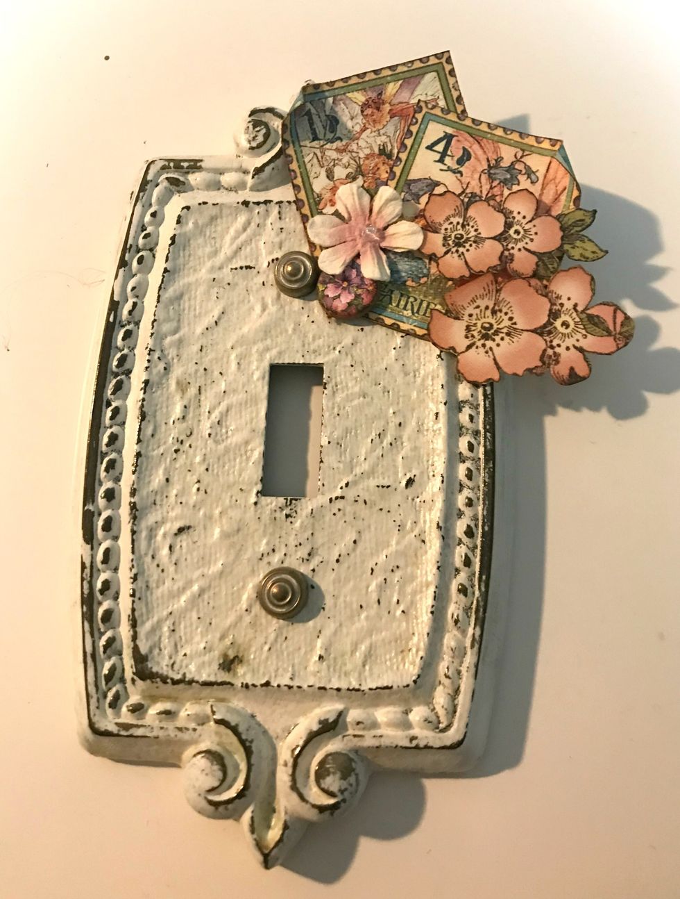 In the top right corner, adhere 2 stamps, 1 bunch of 3 flowers, 1 single flower, 1 daisy and 1 chipboard piece. Use foam squares as desired. Roll one corner down on each stamp.