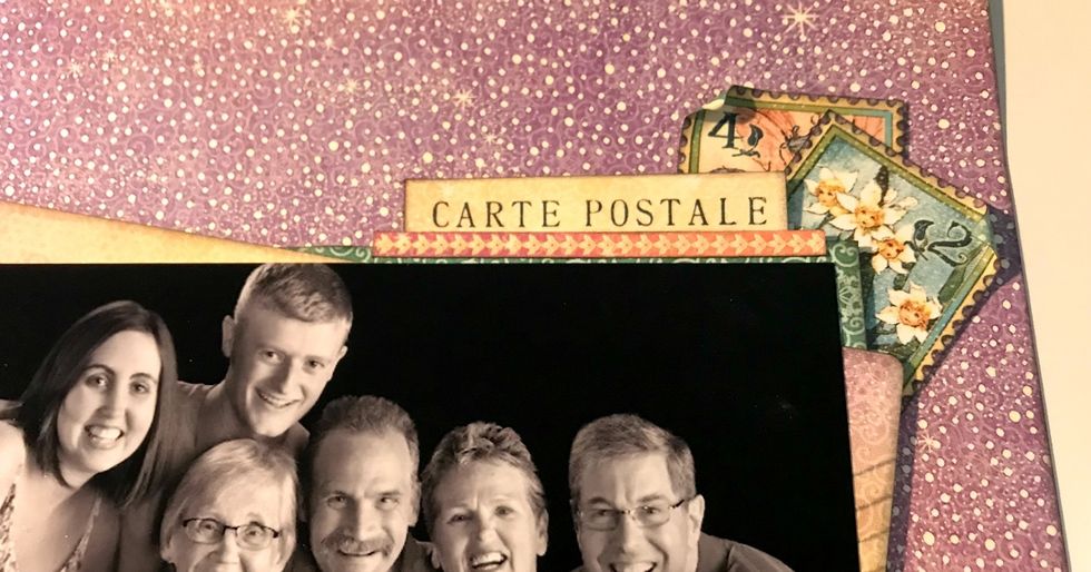 In the top right corner of blue paper, adhere the pink floral border & foam square the Carte Postale piece to the same area. Adhere 2 stamps in corner. Roll one corner down on each stamp.