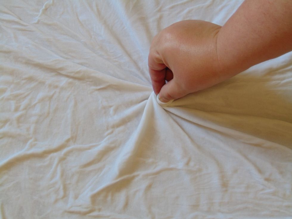 In the very middle of the shirt pinch and twist a bit of the shirt