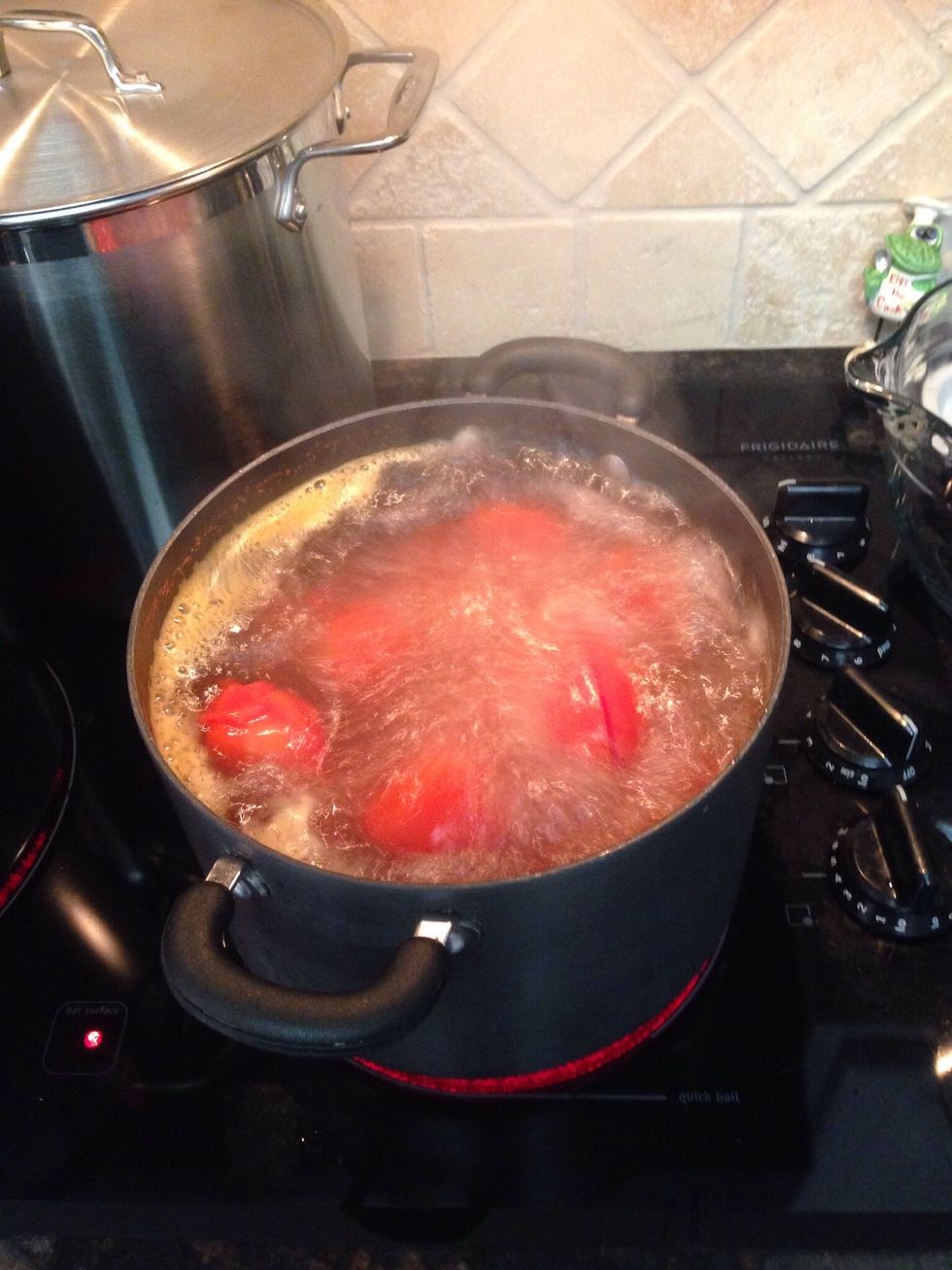 In this pot filled with sterile water, bring to boil & in batches drop the scored tomatoes. Boil 2-3 minutes each. Just until the skin starts to peel.