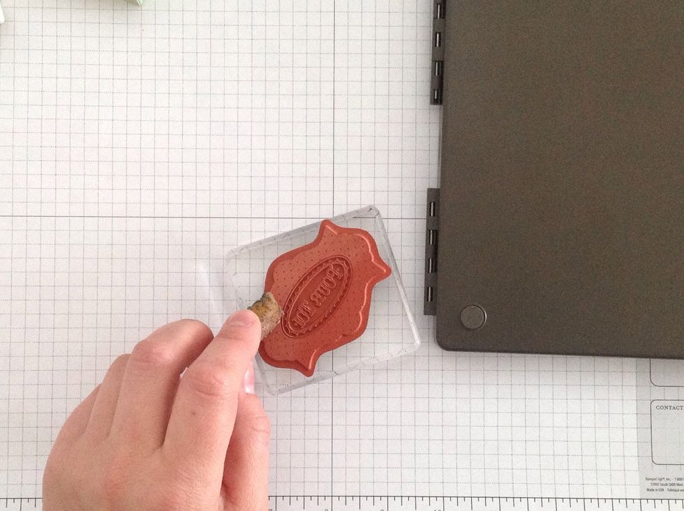 In this step, take your adhesive remover (it's like a gum eraser), and rub the stamp surface. It will change color noticeably. Rub until the entire image turns lighter orange.