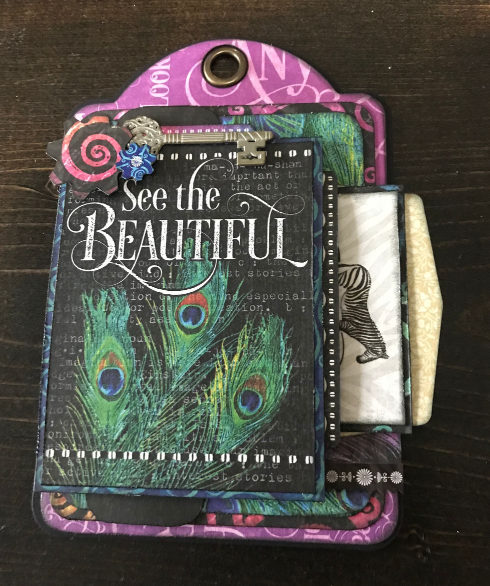 In top left corner of See the card, adhere a metal key. Use adhesive and foam squares to adhere a small flower and the patterned paper flower.